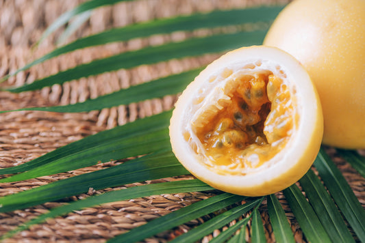 Yellow passionfruit with palm leaves on rattan background.
